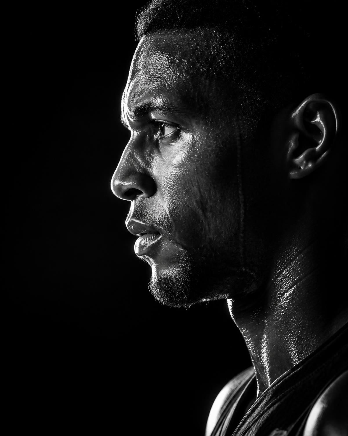 Close-up profile portrait of an athlete against a dark background
